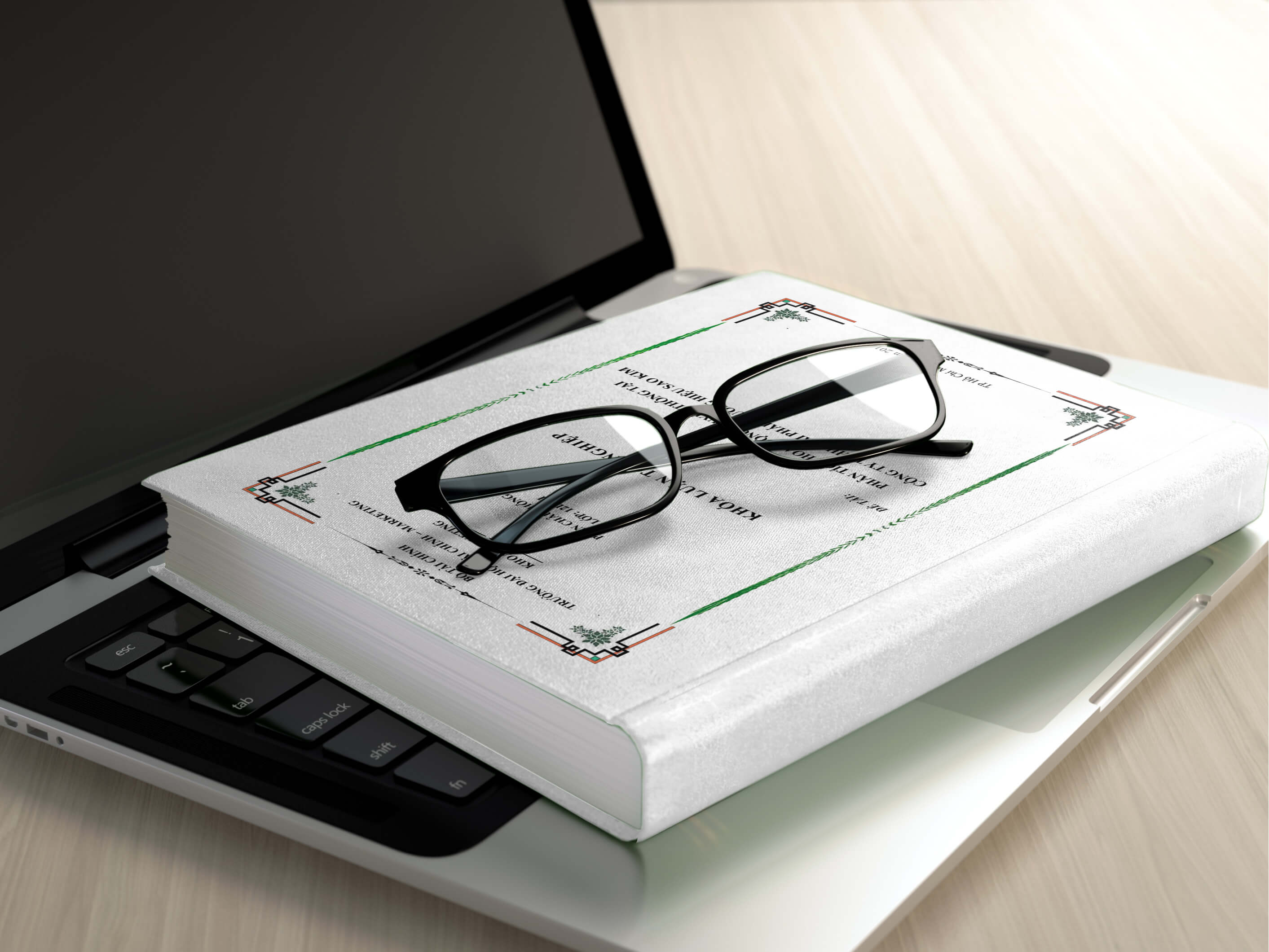 photo of reading glasses on a book on top of a laptop